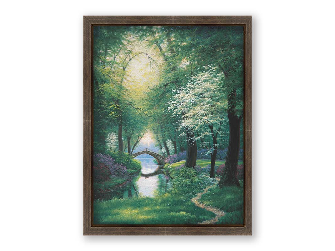 A painting of a path through a forested park in spring, running alongside a stream to a bridge. Printed on canvas and framed.