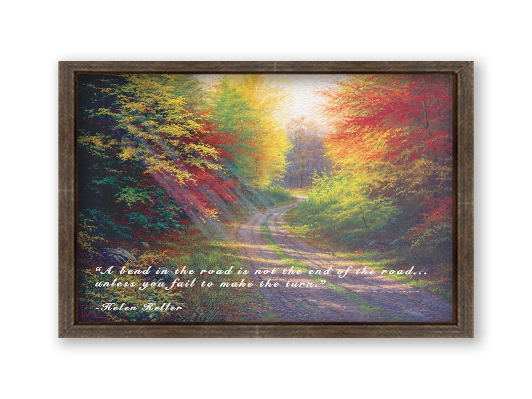 A landscape painting of a gravel road winding thorugh an autumn forest with a mix of vibrant red, yellow, and green leaves. The Helen Keller quote "A bend in the road is not the end of the road... unless you fail to make the turn" is overlaid in white across the bottom. Printed on canvas and framed.