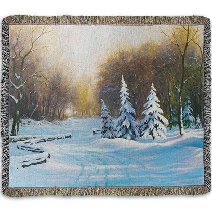 Woven blanket with a winter landscape design featuring trees and snow.
