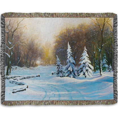 Woven blanket with a winter landscape design featuring trees and snow.