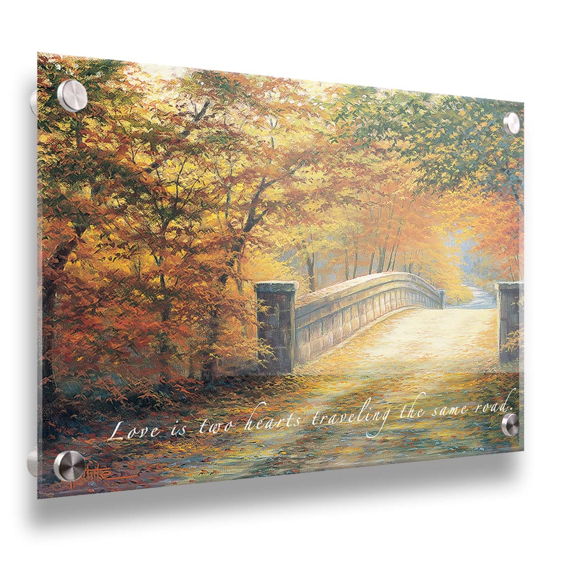 A painting looking down a bridge road during fall. The trees lining the road have turned yellow and orange for autumn, and some of their fallen leaves are scatted along the path. The quote "Love is two hearts traveling the same road" is overlayed across the image in white. Printed on acrylic.