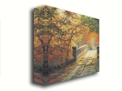 A painting looking down a bridge road during fall. The trees lining the road have turned yellow and orange for autumn, and some of their fallen leaves are scatted along the path. It is overlayed in the bottom right with an excerpt of Proverbs 3:5-6 of the Bible, reading "Trust in the Lord with all your heart... and he will make your paths straight." Printed on canvas.