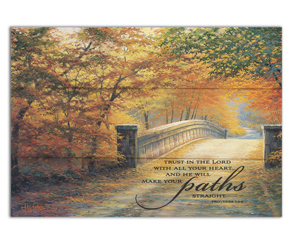 A painting looking down a bridge road during fall. The trees lining the road have turned yellow and orange for autumn, and some of their fallen leaves are scatted along the path. It is overlayed in the bottom right with an excerpt of Proverbs 3:5-6 of the Bible, reading "Trust in the Lord with all your heart... and he will make your paths straight." Printed on a box board.