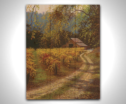 A painting of a dirt path passing a vineyard after harvest. At the far end of the path is a red barn. Printed on a wood pallet.