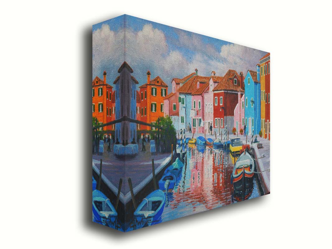 A painting of a canal in the Murano islands in Italy. Several small boats are docked along the sides, and bright, colorful buildings line the paths. Printed on canvas.