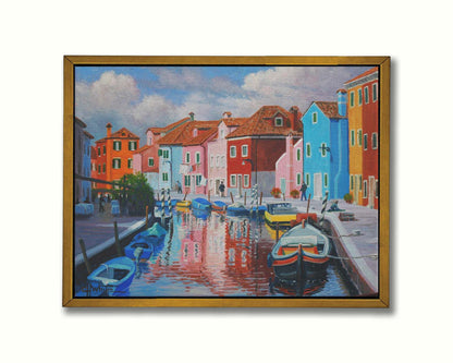 A painting of a canal in the Murano islands in Italy. Several small boats are docked along the sides, and bright, colorful buildings line the paths. Printed on canvas in a float frame.