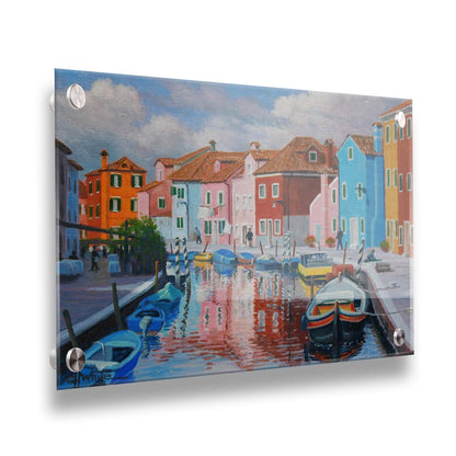 A painting of a canal in the Murano islands in Italy. Several small boats are docked along the sides, and bright, colorful buildings line the paths. Printed on acrylic.