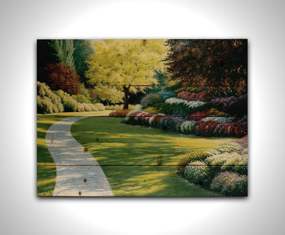 A painting of a cobblestone path through a sunny, colorful, tidy garden. Printed on a wood pallet.