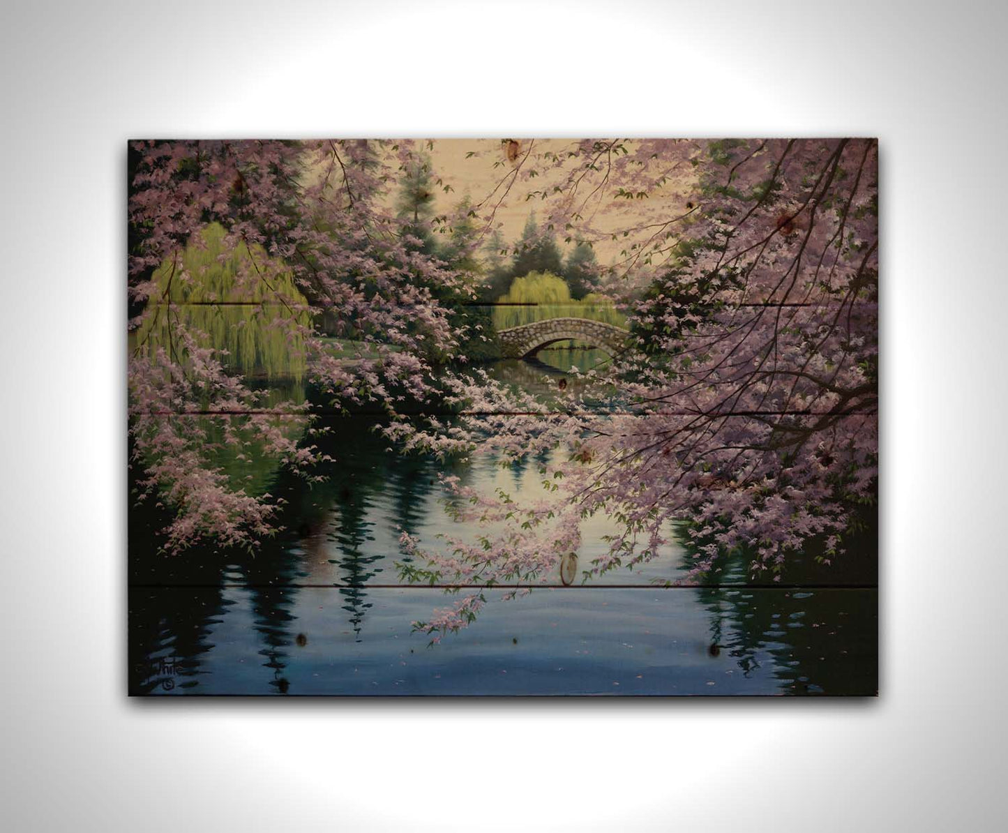 A painting of Beacon Hill Park in Victoria, British Columbia, Canada, during the springtime cherry blossom season. Pink blossoms over Goodacre Lake frame a stone bridge in the background. Printed on a wood pallet.