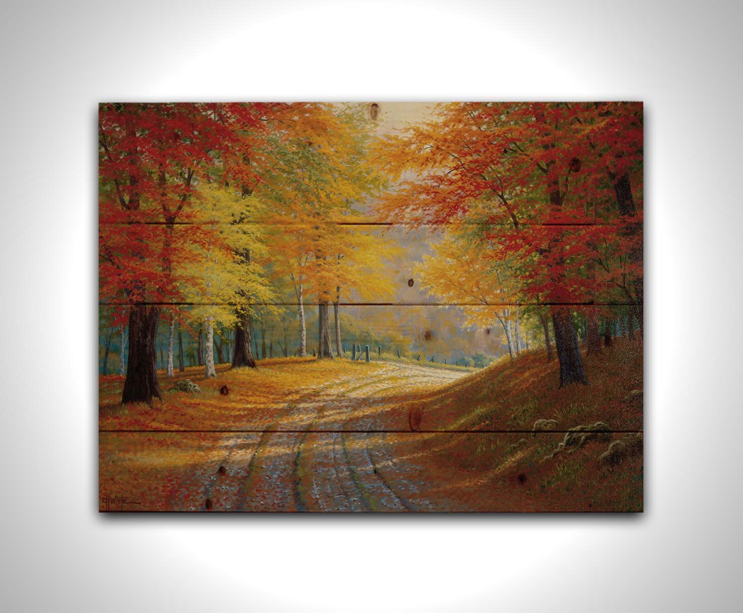 A painting of a gravel road through a forest in autumn. Orange red, and yellow leaves coat the ground and cover the trees, highlighted by bright sunlight. Printed on a wood pallet.