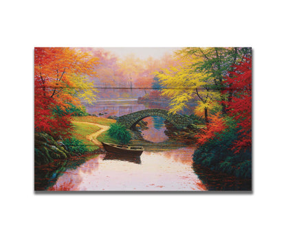 A painting of an idyllic fall scene, with colorful maples surrounding a river crossed by a small stone bridge. A rowboat is tied down near the bridge. Printed on a box board.