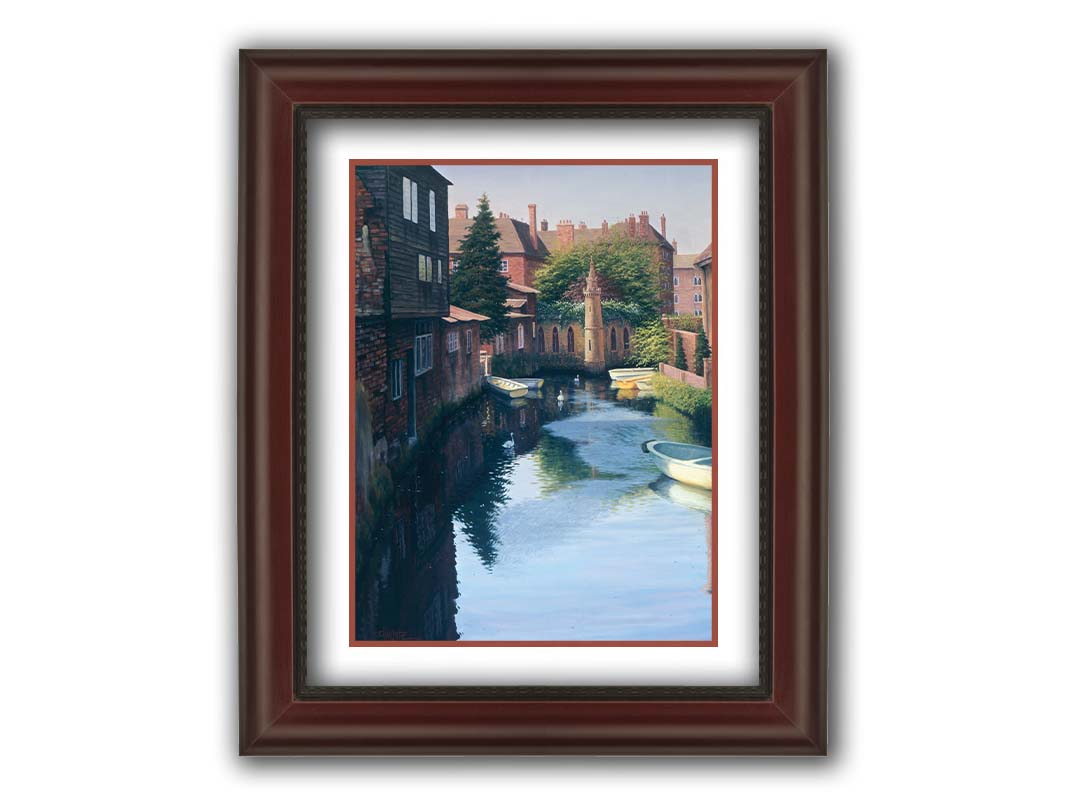 A painting of a canal in Canterbury in Kent, England. A few small row boats are docked along the waterway between historic red brick buildings. Printed on paper, matted, and framed.