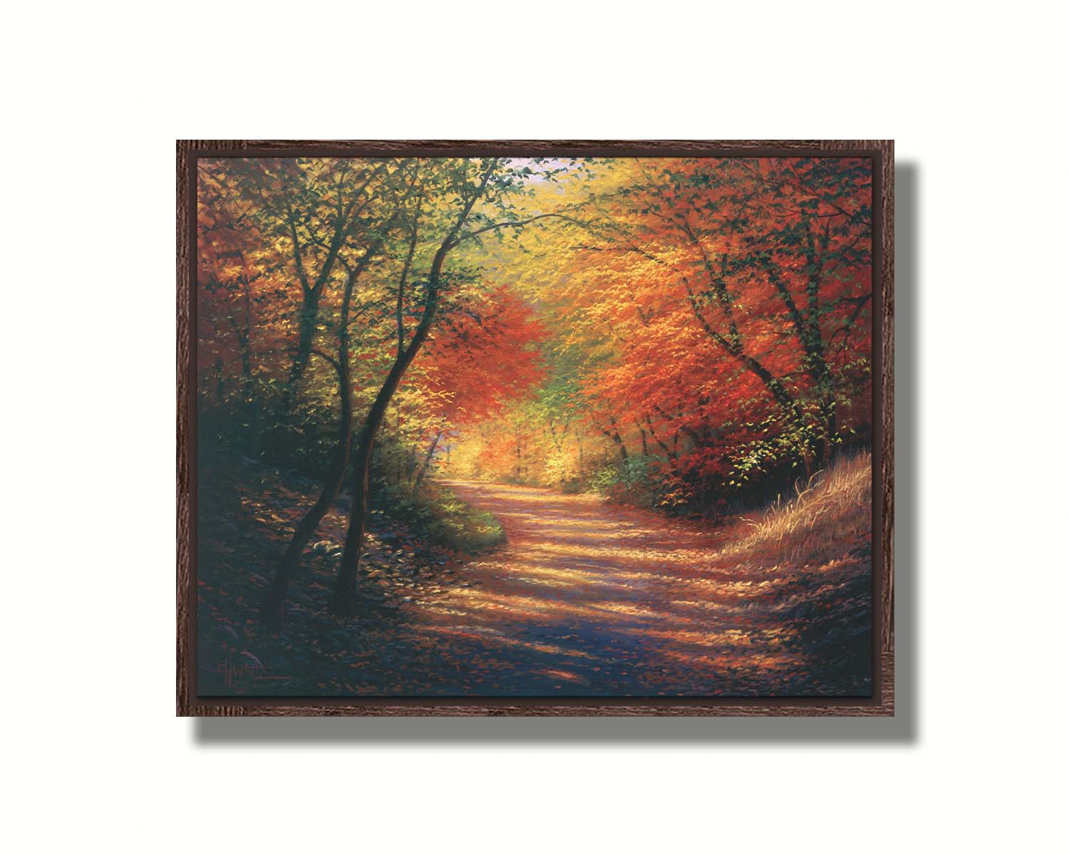 A painting of a path through the woods in autumn, with orange leaves falling onto the road. Printed on canvas in a float frame.