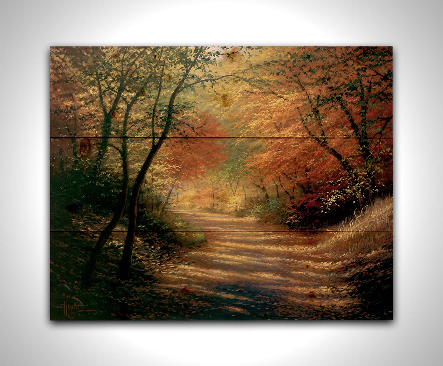 A painting of a path through the woods in autumn, with orange leaves falling onto the road. Printed on a wood pallet.