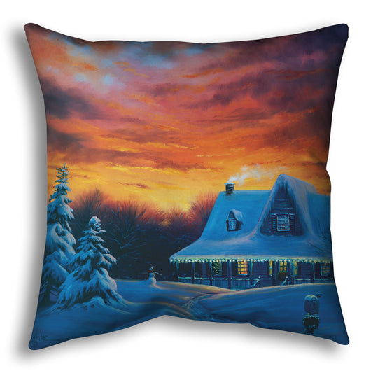 A throw pillow designed with a painting of a house, decorated for Christmas, covered in and surrounded by snow.