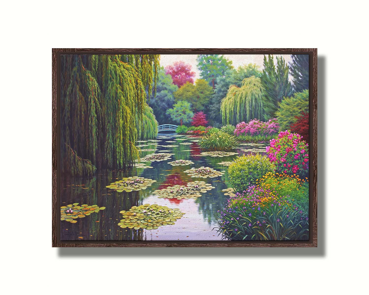 A painting of Claude Monet's garden at his home in Giverny, France. A pond dotted with lily pads is surrounded by weeping willows and colorful flower bushes in pinks, reds, yellows, and purples. Printed on canvas in a float frame.