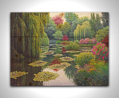 A painting of Claude Monet's garden at his home in Giverny, France. A pond dotted with lily pads is surrounded by weeping willows and colorful flower bushes in pinks, reds, yellows, and purples. Printed on a wood pallet.