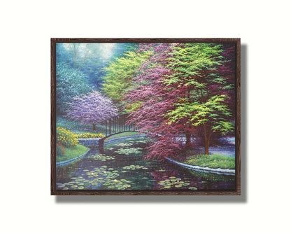 A painting of a peaceful garden pond covered in lily pads, and surrounded by vibrant red and yellow flowers, striking red maples, and blossoming white and pink trees. Printed on canvas in a float frame.