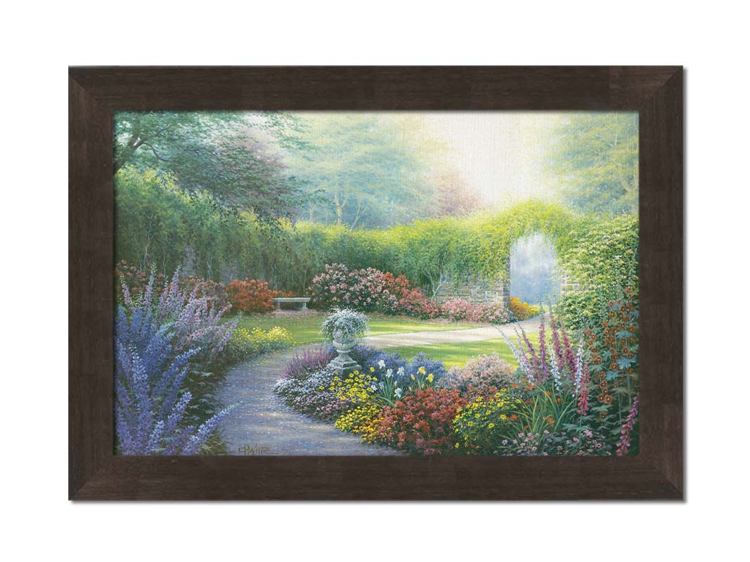 A painting of a path through a garden, filled with flowers in every color– including irises, foxgloves, butterfly bush, and more. A vine-covered stone wall with an archway surrounds the area. Printed on canvas and framed.