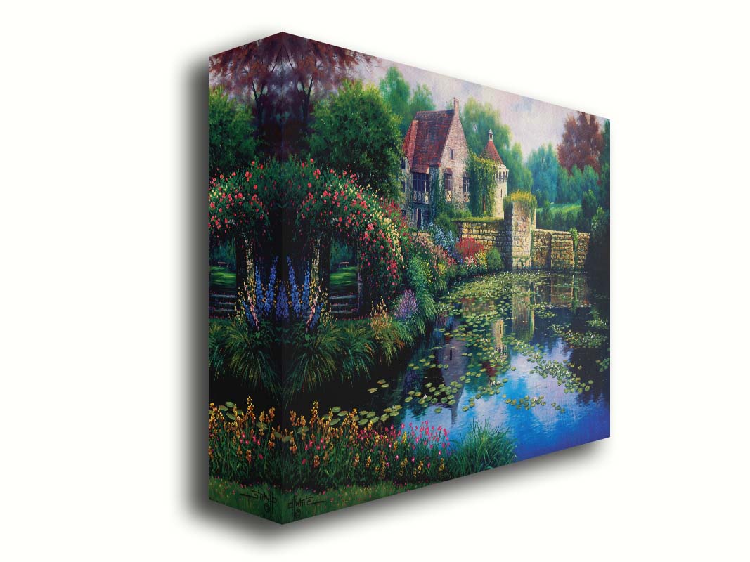 A painting of a pond covered in lily pads– bordered by a garden of flowers in every color, as well as an old stone wall covered in mosses and vines. Beyond it is a home with historic architecture, also supporting vines. The plants and structures are all well-maintained and not overgrown. Printed on canvas.