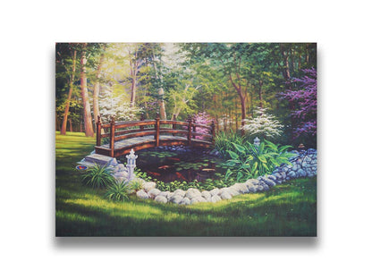 A painting of a garden koi pond, surrounded by stones and crossed by a small bridge. Lily pads grow in the water, and orange and white koi carp swim between them. Printed on canvas.