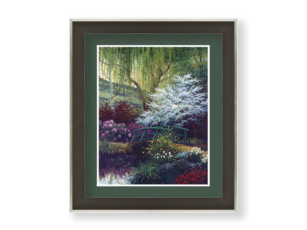 A painting of Claude Monet’s iconic water lily pond in Giverny, France, featuring a small bridge over the canal that brings water into the pond. It is surrounded by willow trees, trees with white and red blossoms, and a variety of flowers. Printed on paper, matted, and framed.