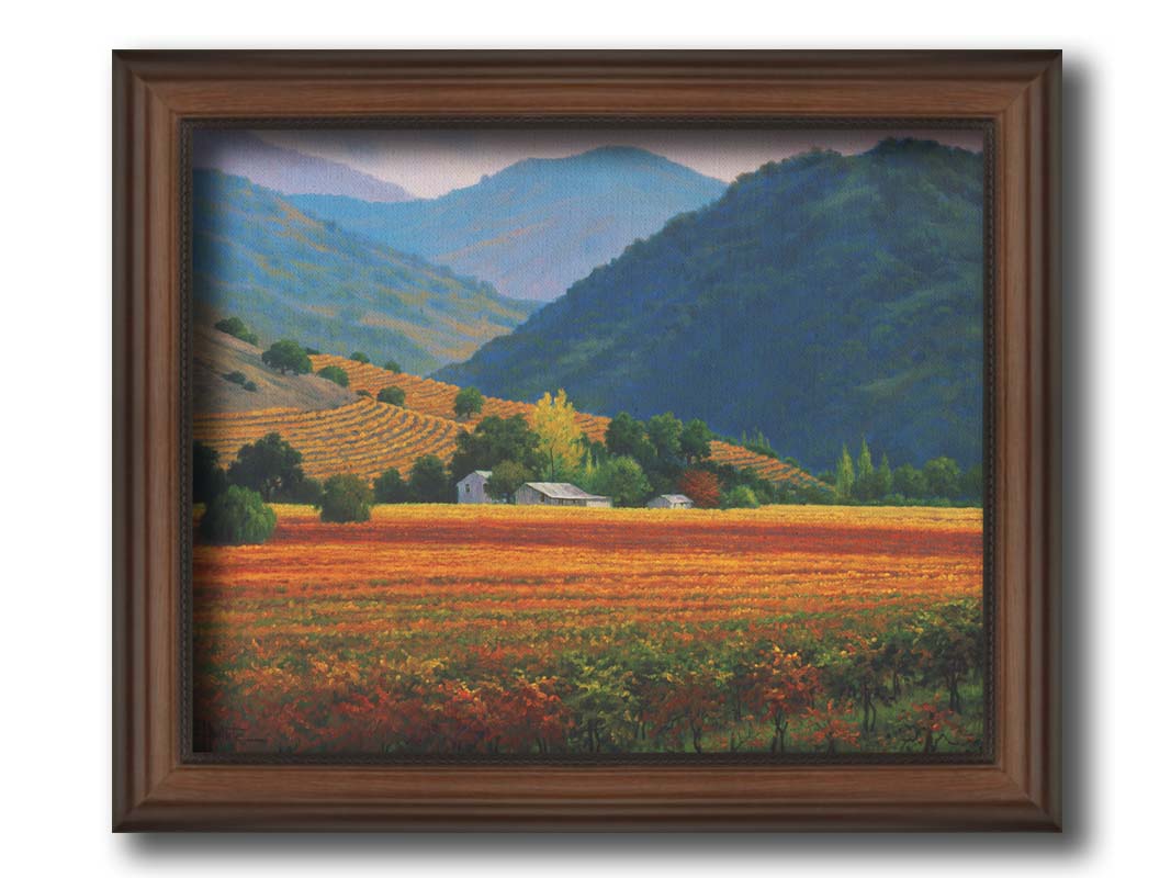 A landscape painting of the Napa Valley wine region in California. Colorful orange, red, and green vineyards are nestled among forested mountains. Printed on canvas and framed.