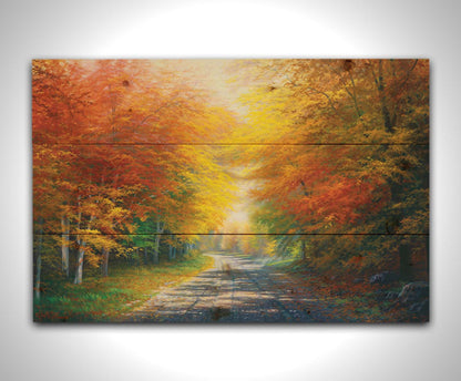 A painting of a fall landscape with vibrant red, orange, and yellow trees lining a gravel road. Printed on a wood pallet.