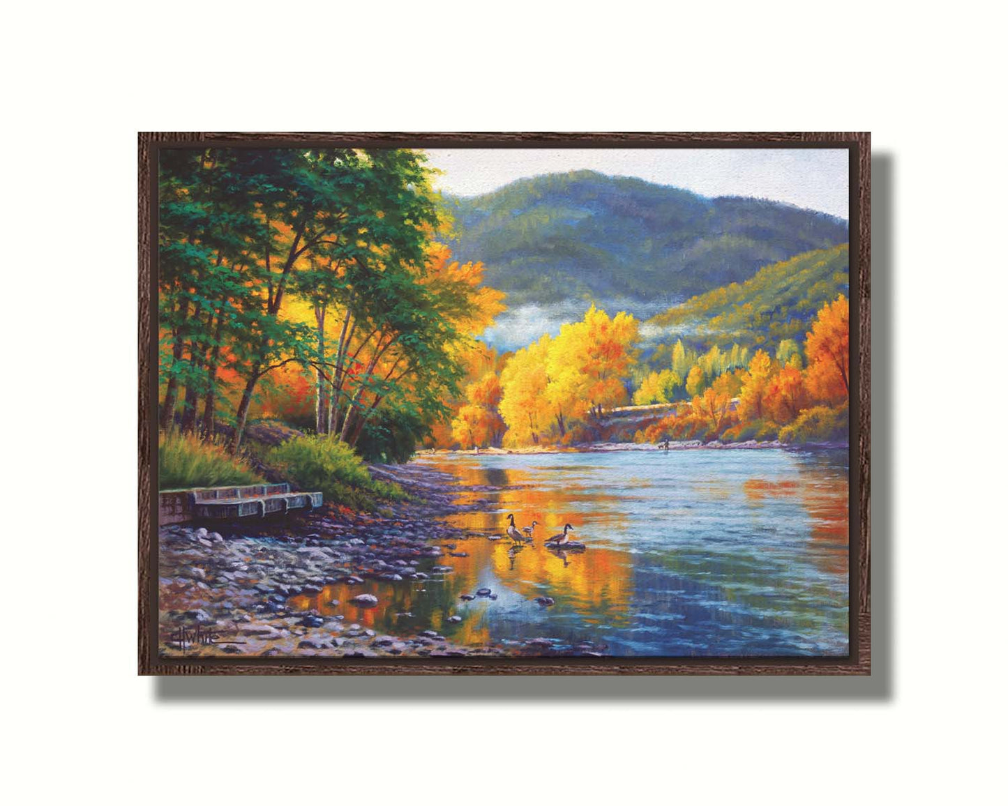 A landscape painting of the vibrant orange and yellow trees of the Rogue River in Oregon, with a few geese waddling in the shallows by the rocky shore. Printed on canvas in a float frame.