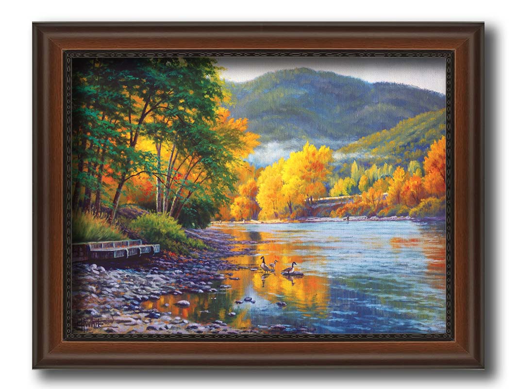 A landscape painting of the vibrant orange and yellow trees of the Rogue River in Oregon, with a few geese waddling in the shallows by the rocky shore. Printed on canvas and framed.