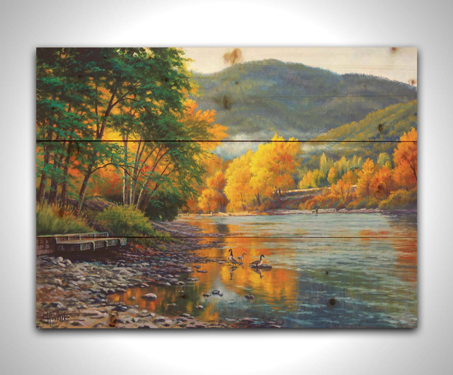 A landscape painting of the vibrant orange and yellow trees of the Rogue River in Oregon, with a few geese waddling in the shallows by the rocky shore. Printed on a wood pallet.