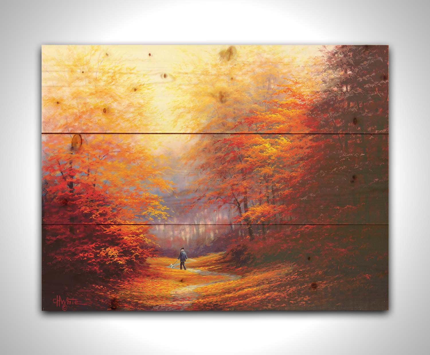 A painting of resplendent orange and red trees, a winding sidewalk through the woods, and a person walking their dog along the path. Printed on a wood pallet.