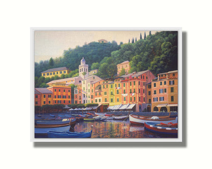 A painting of the colorful fishing town of Portofino. Many small boats are docked in the waters in the foreground, and the steep hills in the background are lush with trees. Printed on canvas in a float frame.