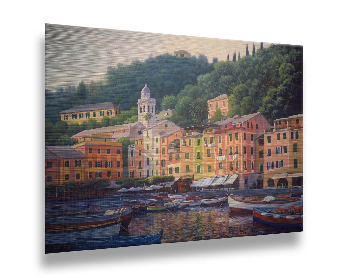 A painting of the colorful fishing town of Portofino. Many small boats are docked in the waters in the foreground, and the steep hills in the background are lush with trees. Printed on metal.