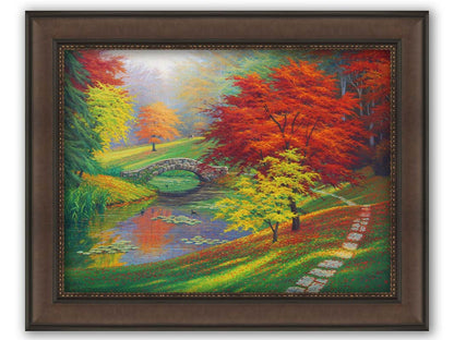 A painting of a fall park scene. Vibrant trees in hues of orange and red adorn the landscape while leaves gently fall. A stone bridge over a pond with lily pads and ducks. Printed on canvas and framed.