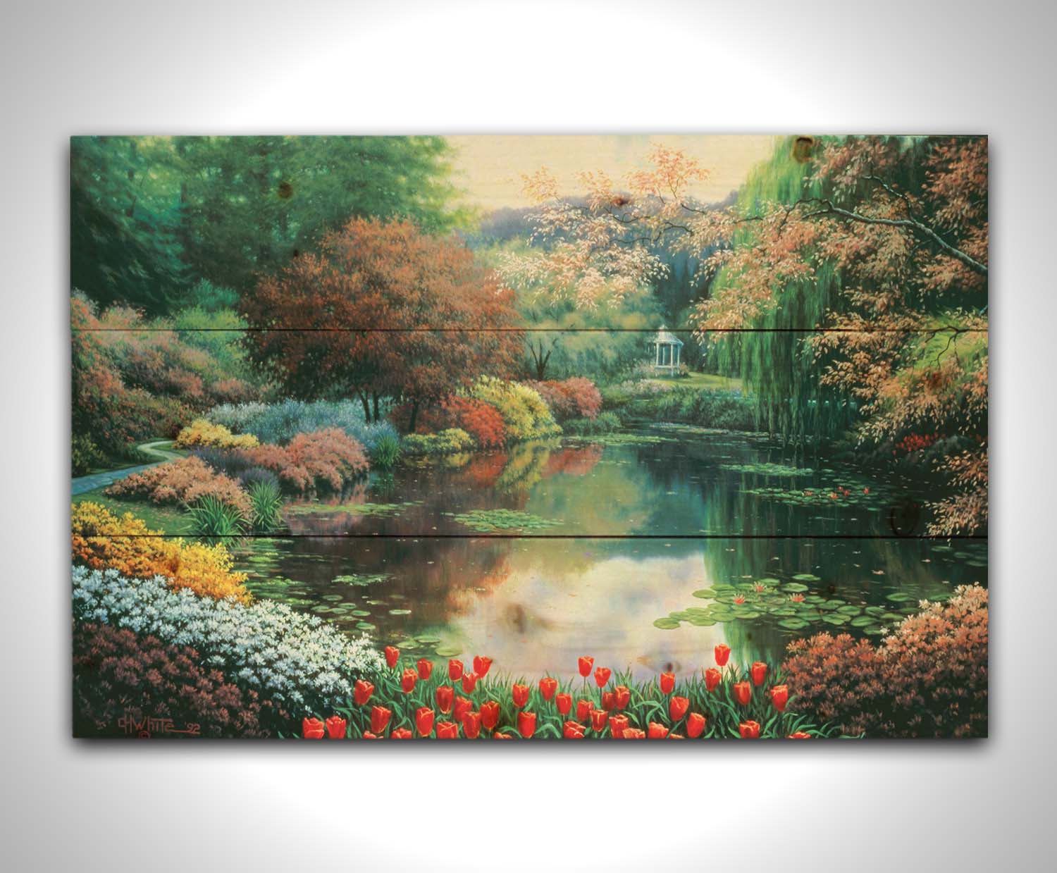 A painting of a landscape of a garden pond adorned with lily pads and vibrant flowers, with a gazebo in the distance. Printed on a wood pallet.