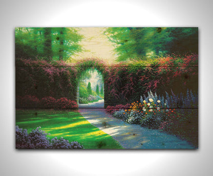 A painting of a garden path, adorned with vibrant flowerbeds. Around the garden stands a wall covered in flowering vines, with an archway for the path. Printed on a wood pallet.