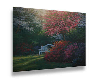 A painting of a garden bench peeking between vibrant flower bushes in red, pink, purple, and blue, all beneath pink and white blossoming trees. Printed on metal.