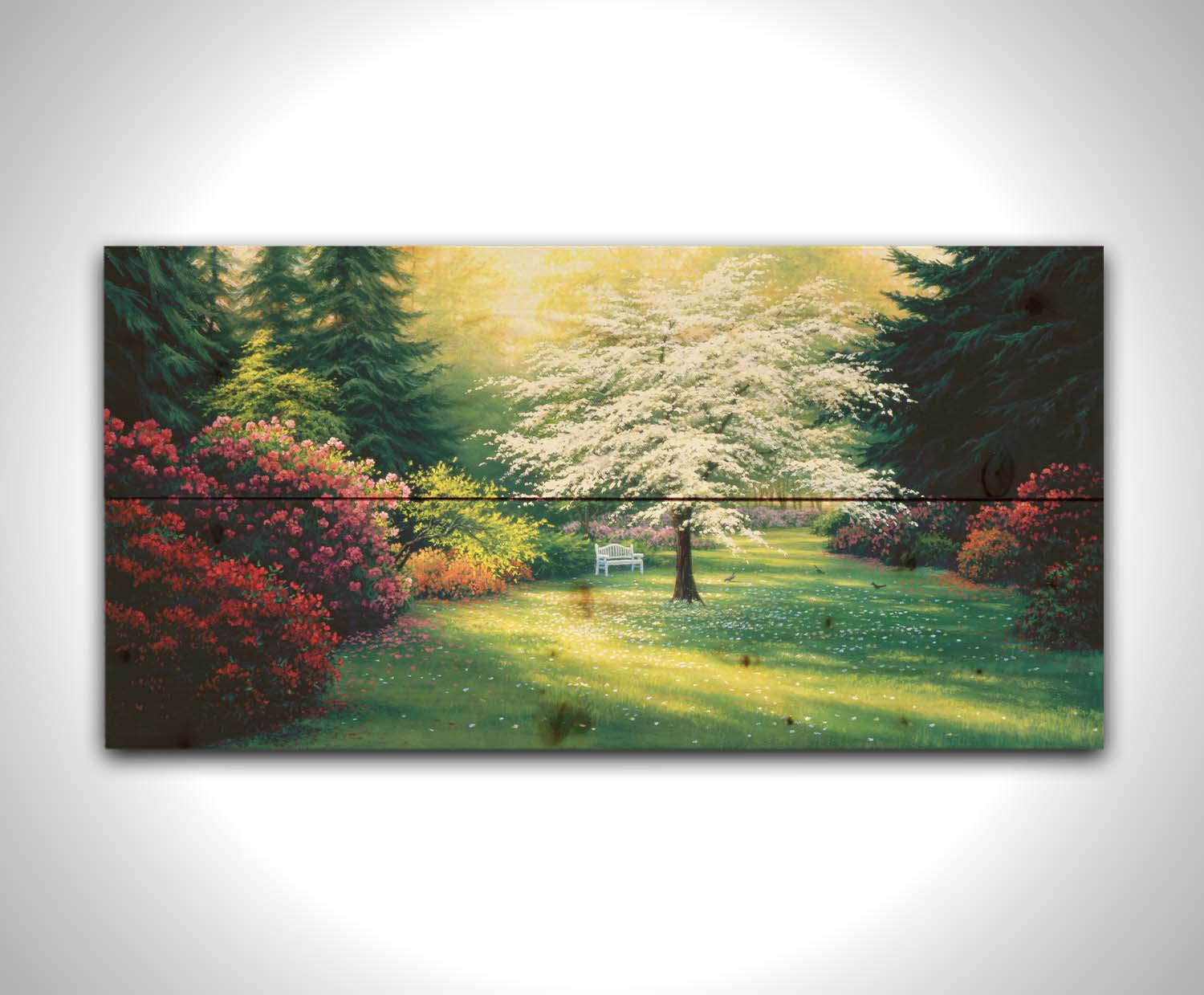 A painting of a park during a spring morning. Bushes and trees are blossoming with colorful flowers, and dark deep evergreens which contrast the warm morning light. Printed on a wood pallet.