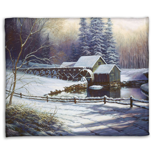 Coral fleece blanket with a winter landscape design featuring a cabin and snowy trees.