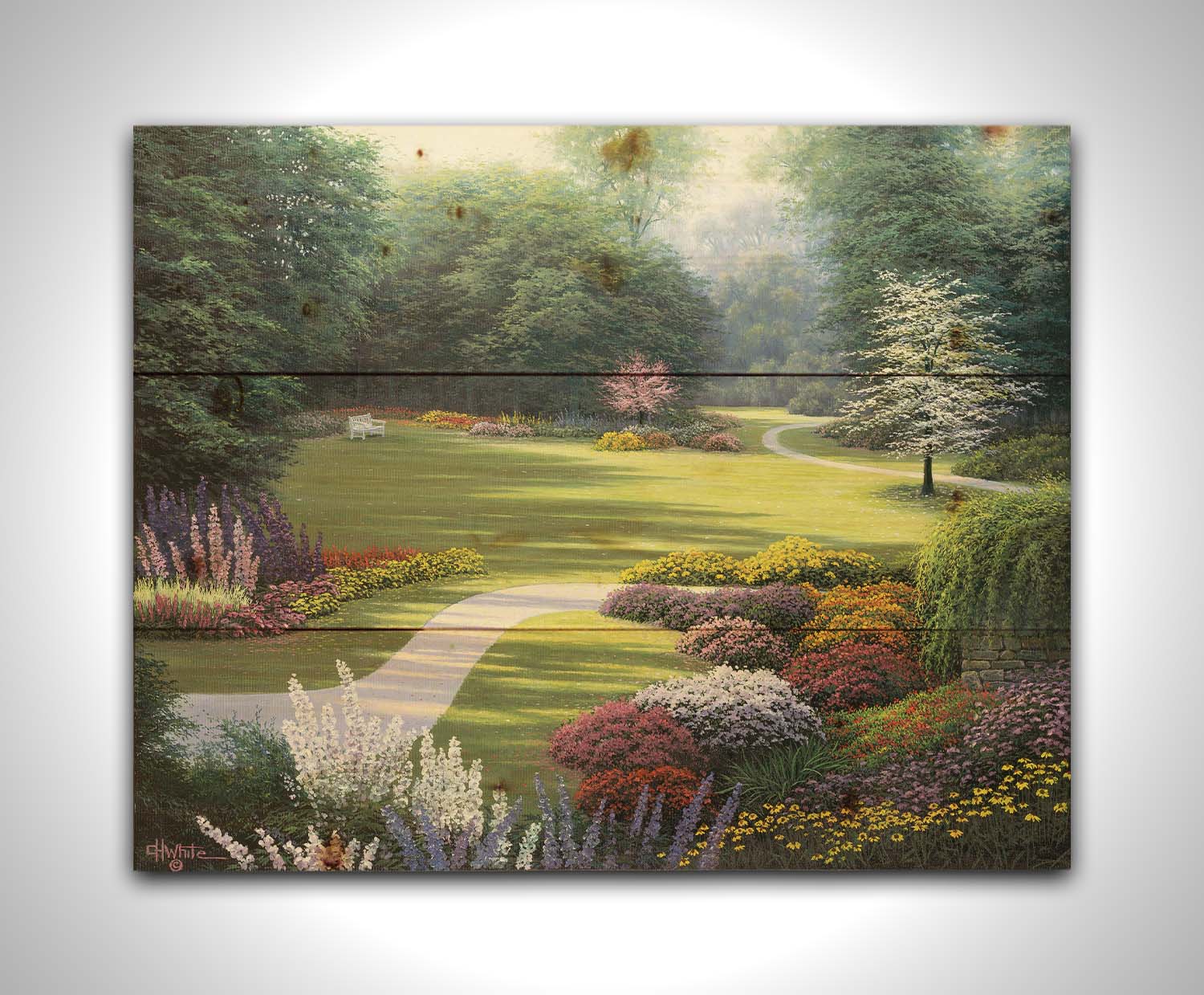 A painting of a sunny park. The open space of the grassy lawn is bordered by an abundance of colorful flowers and surrounding by trees. Printed on a wood pallet.