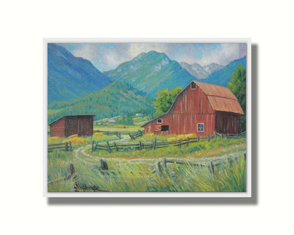 A painting of a red barn and shed surrounded by green pastures. Forested mountains stand tall in the background. Printed on canvas in a float frame.