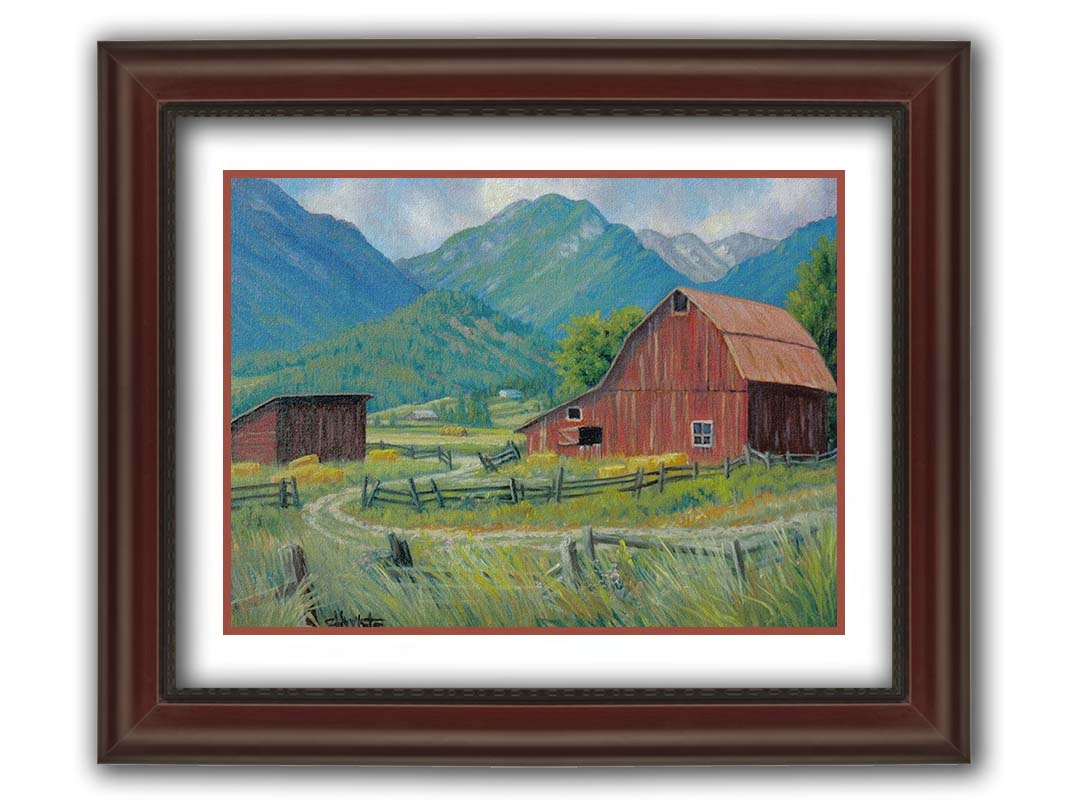 A painting of a red barn and shed surrounded by green pastures. Forested mountains stand tall in the background. Printed on paper, matted, and framed.