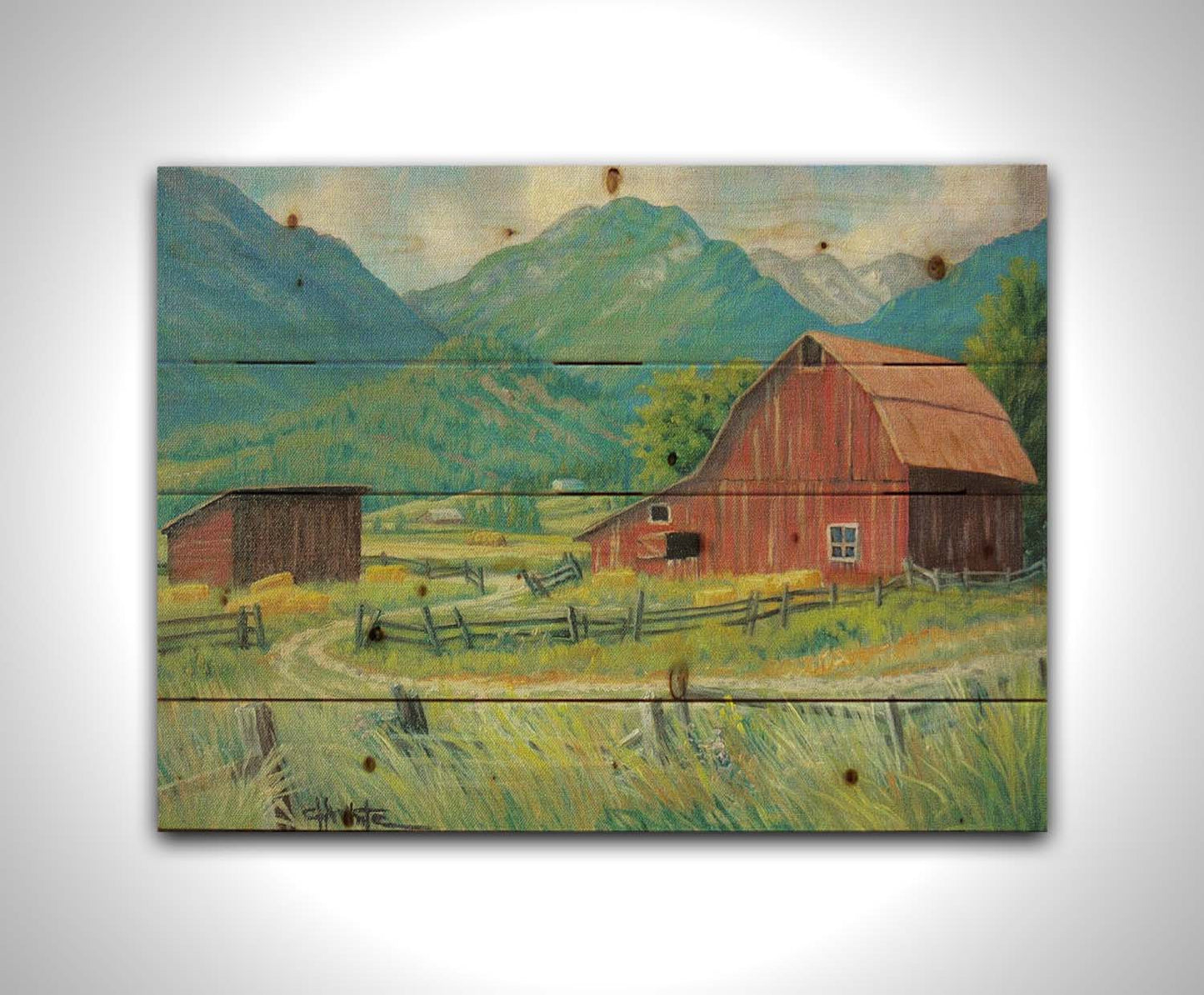 A painting of a red barn and shed surrounded by green pastures. Forested mountains stand tall in the background. Printed on a wood pallet.