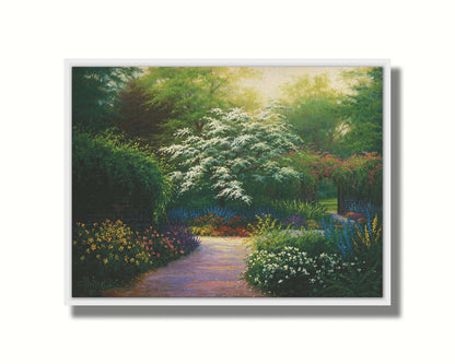 A painting of a brick wall surrounding a flower garden in a full spectrum of colors. A tree blossoming white stands central in contrast to the colorful scene. Printed on canvas in a float frame.