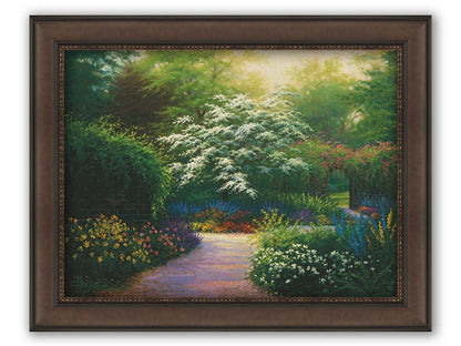 A painting of a brick wall surrounding a flower garden in a full spectrum of colors. A tree blossoming white stands central in contrast to the colorful scene. Printed on canvas and framed.