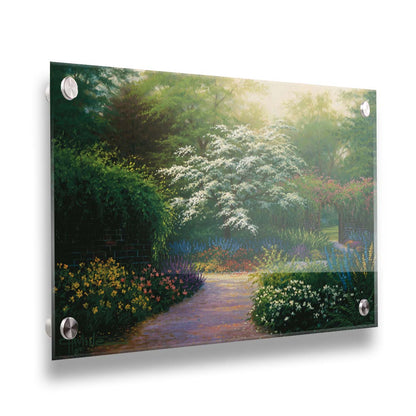 A painting of a brick wall surrounding a flower garden in a full spectrum of colors. A tree blossoming white stands central in contrast to the colorful scene. Printed on acrylic.