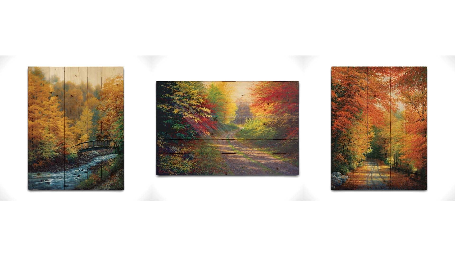 A collection of landscape paintings depicting autumn scenery. Forests of orange, yellow, red, and green trees line roads and rivers beneath white skies. Light trickles down through the leaves in a beautiful dreamlike appearance. Printed on a wood pallet.