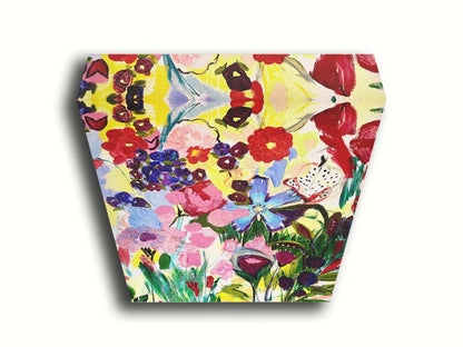 An abstract painting of a vibrant garden, simplified with flat colors and shapes. Petals in purple, red, pink, blue, and more contrast against a pale yellow background. Printed on canvas.