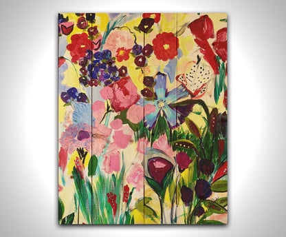 An abstract painting of a vibrant garden, simplified with flat colors and shapes. Petals in purple, red, pink, blue, and more contrast against a pale yellow background. Printed on a wood pallet.